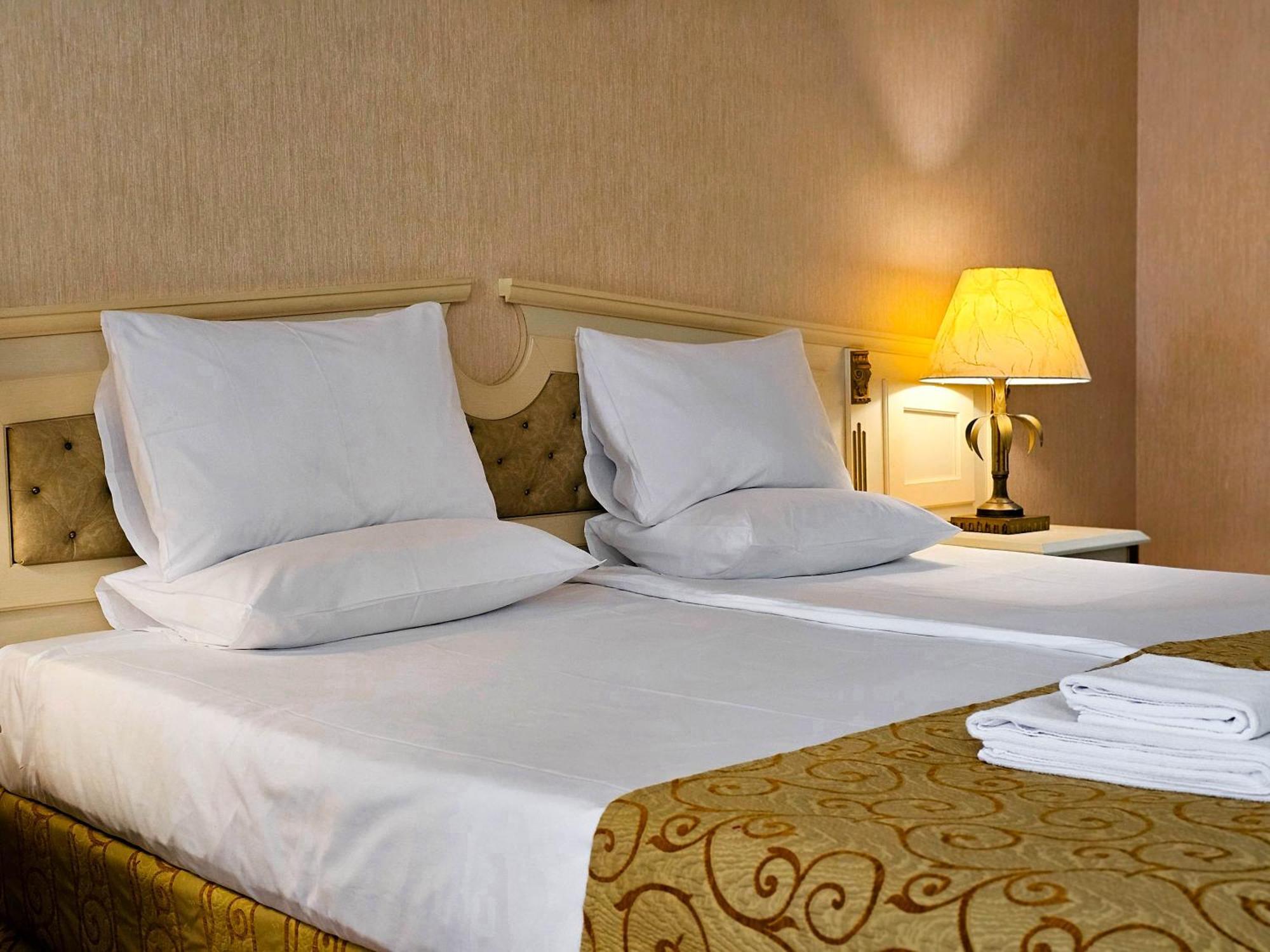Imperial Palace Hotel Pantai Sunny Luaran gambar A bed with pillows and a lamp